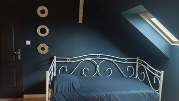 Een kamer met een bed, dakraam en decoratieve muurkunst.