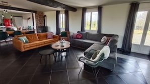 Ein großzügiger Wohnbereich mit Sofa, Sessel und Esstisch.