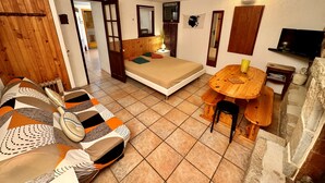 Ein kleines Zimmer mit Bett, Tisch, Stuhl und Fernseher.