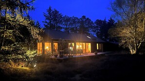 A modern house with large windows, a deck, and a well-lit interior. - Traumhaus Römö für 6 Personen. Unesco Wattenmeer (Rømø)