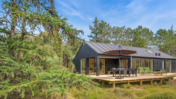 A modern cabin with a deck, large windows, and a covered outdoor seating area. - Traumhaus Römö für 6 Personen. Unesco Wattenmeer (Rømø)