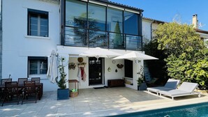 A modern house with a swimming pool, outdoor furniture, and a clear blue sky. - Villa D'architecte Avec Piscine au Coeur D'un Parc (Villeneuve-lès-Avignon)