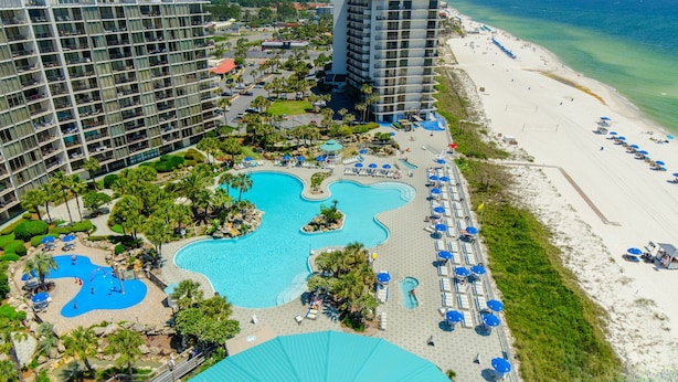 A resort with multiple swimming pools, a beach, and high-rise buildings.