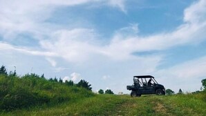 A vehicle on a grassy field with a clear sky. - Quaint little home (La Grange)
