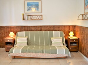 Relax in this inviting room with a sofa, bedside tables, and a framed picture.