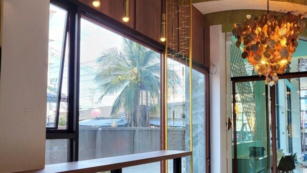 Un interior moderno con ventanas amplias, techo curvo y un candelabro único.