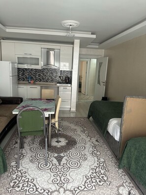 A compact room with a kitchenette, a dining table, and a bed. - Espinaz Apart Otel  (Van)