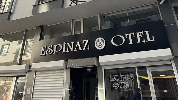 Un edificio de varios pisos con un letrero que dice "Espinaz Hotel" al nivel de la calle.