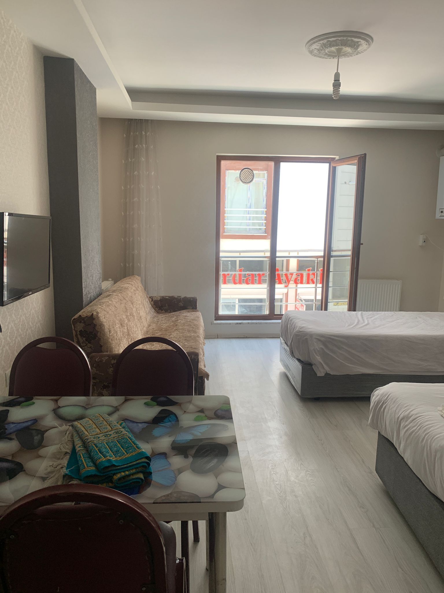 Habitación de hotel con mesa de comedor, dos sillas, un sofá, una cama y un balcón con vistas.