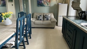 A modern kitchen with a dining area, a sofa, and a coffee machine. - Remarkable 3-bed House in Belfast (Belfast)