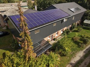 A modern building with a flat roof, solar panels, and a covered walkway.