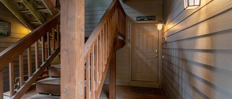 A wooden staircase leading to a door with a sign above it.
