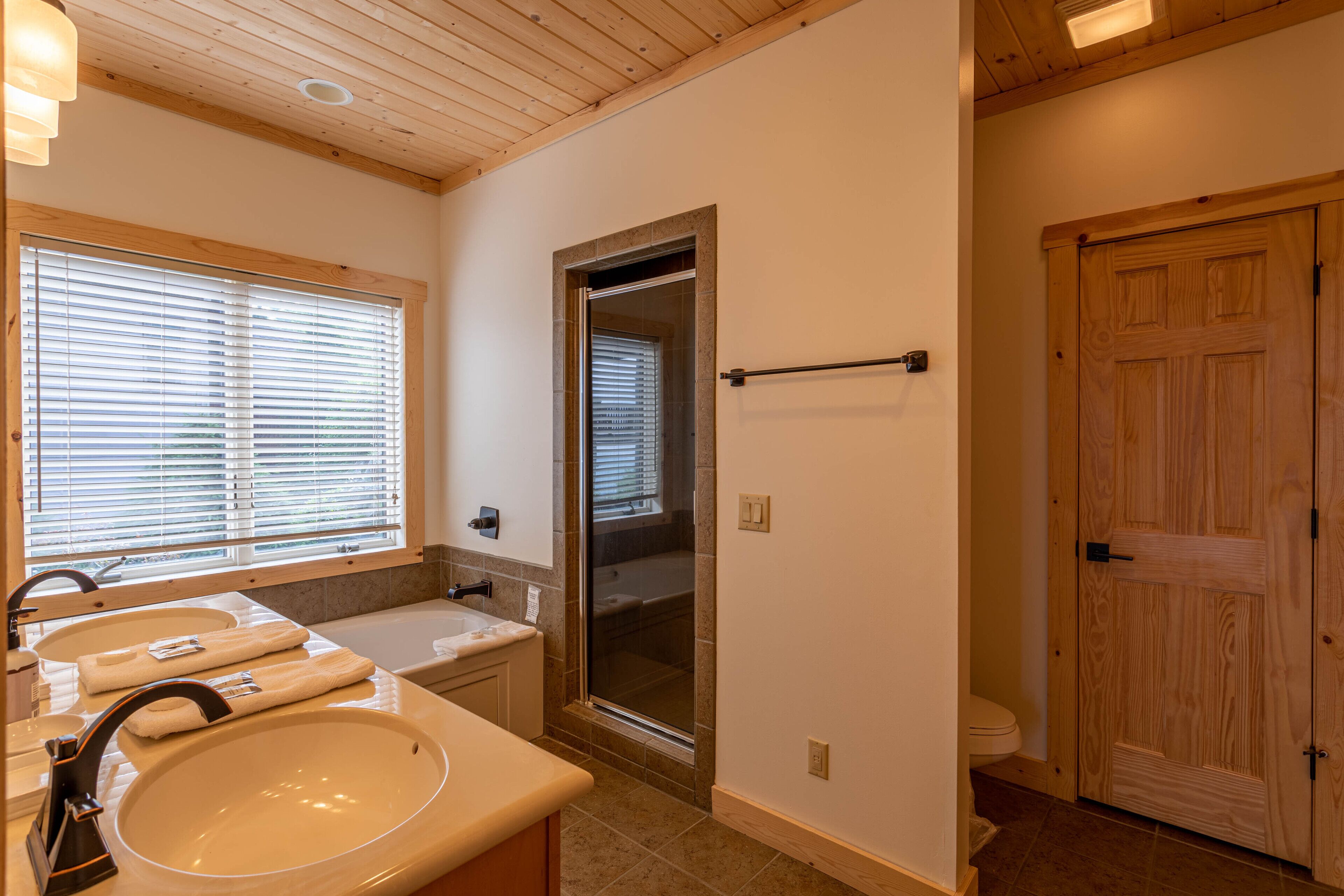 A bathroom with a large sink, a bathtub, and a shower.