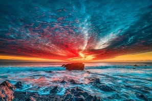 A sunset over the ocean with a rocky shoreline. - Cozy Retreat Sleeps 4 With Parking (Helston)