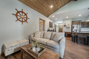 Relax in a welcoming space with a comfortable sofa, coffee table, and kitchen area, perfect for socializing and meal preparation.