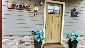 A wooden house with a number '80' on the wall, a wooden door, and two potted plants on either side of the door. - Boat Slip Included, Hot Tub, Lakefront resort (Branson)