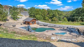 A resort with a pool area, a wooden cabin, and a view of the surrounding forest. - Boat Slip Included, Hot Tub, Lakefront resort (Branson)