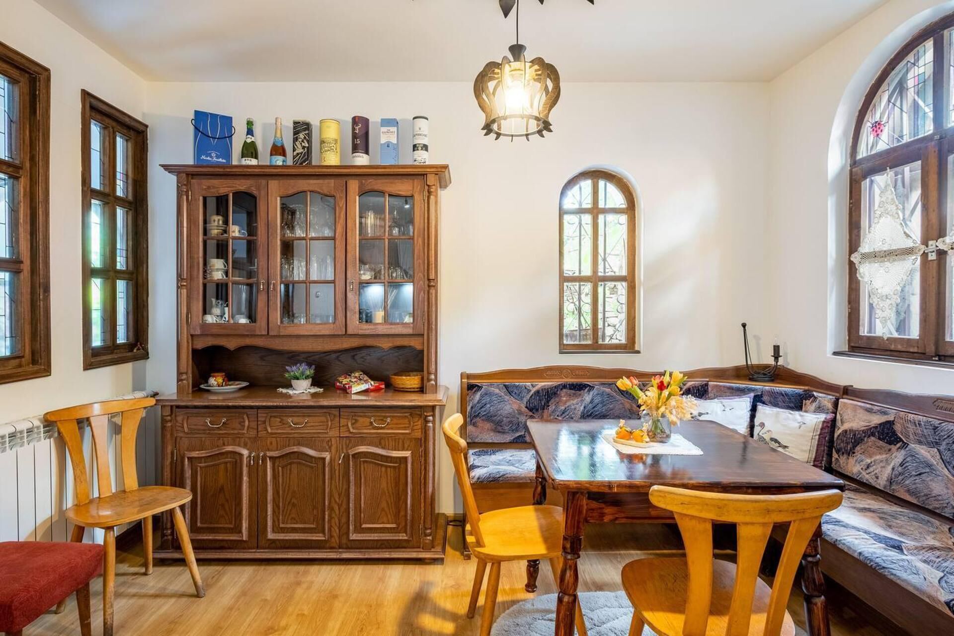 A cozy dining area with a wooden cabinet, a bench, and a table.