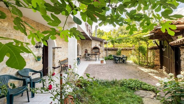 A courtyard with stone flooring, outdoor seating, and a brick oven. - Lovely 5-bed Authentic House in the Arbanasi (Veliko Tarnovo)