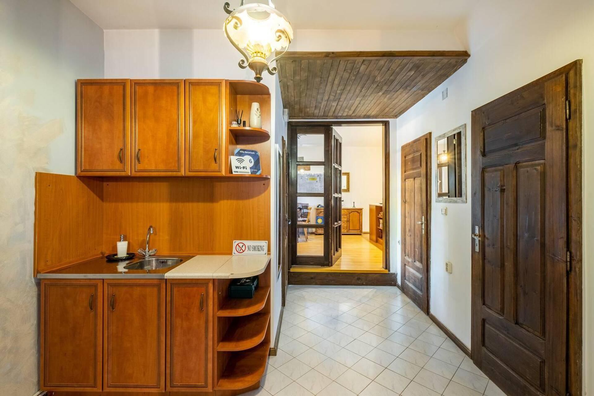 Una cocina con armarios de madera, un lavamanos y un letrero de Wi-Fi.