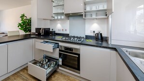 A modern kitchen with white cabinets, a built-in oven, a gas stove, and a sink. - My Chester Luxury 3bedroom Home (Colchester)