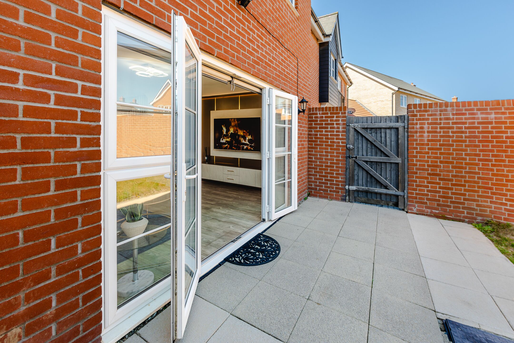 A brick house with a sliding glass door leading to a patio.
