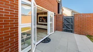 A brick house with a sliding glass door leading to a patio.