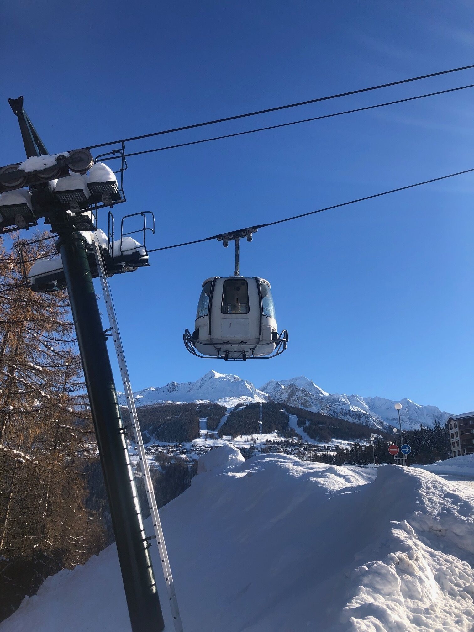 Un téléphérique surplombant un paysage montagneux enneigé.
