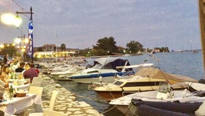 A marina with boats docked along a stone-paved walkway. - 3-bed House Sleeps 7 With Garden (Aktio-Vonitsa)