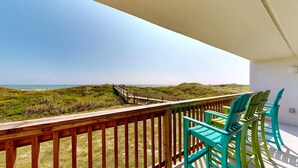 A balcony with a wooden railing, a view of the beach, and turquoise chairs. - Ocean View, Shared Pool/Hot Tub, Boardwalk to Beach (Port Aransas)
