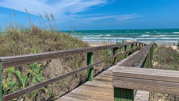 A wooden boardwalk leading to a beach with ocean views. - Ocean View, Shared Pool/Hot Tub, Boardwalk to Beach (Port Aransas)