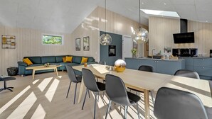 A modern kitchen with a built-in oven and a flat-screen TV.