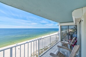 Ein Balkon mit Blick auf Strand und Meer.