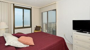 A hotel room with a bed, a television, a chair, and a view of the ocean through a large window. - Bonaire 404-Oceanfront 126th St, Free WiFi, Elev, W/D, AC (Ocean City)