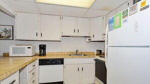 A compact kitchen with white cabinets, a microwave, a coffee maker, a dishwasher, and a refrigerator. - Bonaire 404-Oceanfront 126th St, Free WiFi, Elev, W/D, AC (Ocean City)
