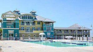 A large hotel with multiple balconies and a swimming pool. - Sunset Island-Fountain Dr 37 #5A-Bayside 67th St, WIFI, Pools, Elev, W/D, AC (Ocean City)