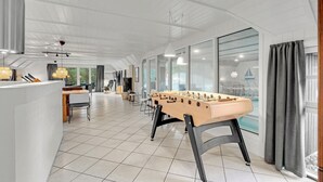 A spacious room with a foosball table, a dining area, and large windows. - Stunning home in Blåvand with sauna (Blåvand)