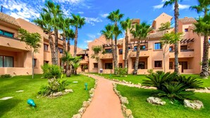 A resort with multiple buildings, palm trees, and a central pathway. - Awesome apartment in Los Alcázares (Los Alcázares)