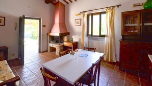 A dining area with a table, chairs, a kitchen with a chimney, and a window with curtains. - Gorgeous home in Arezzo with kitchen (Arezzo)