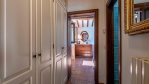A hallway with white paneled doors, a wooden dresser with a mirror, and a blue tiled wall. - Gorgeous home in Arezzo with kitchen (Arezzo)