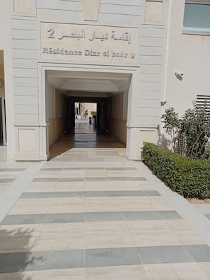 Una entrada a un edificio con un cartel que indica 'Residence Diar el Bahr 2'.