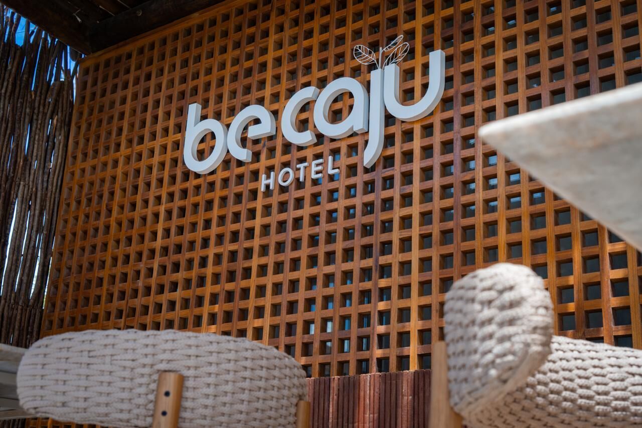 Placa de hotel com design em treliça e o nome 'becaju' em destaque.