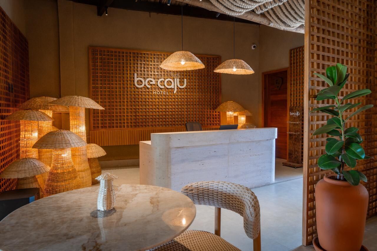 A reception area with a wooden wall, wicker lamps, and a reception desk.