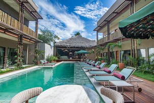 Una piscina al aire libre, sillones reclinables de piscina