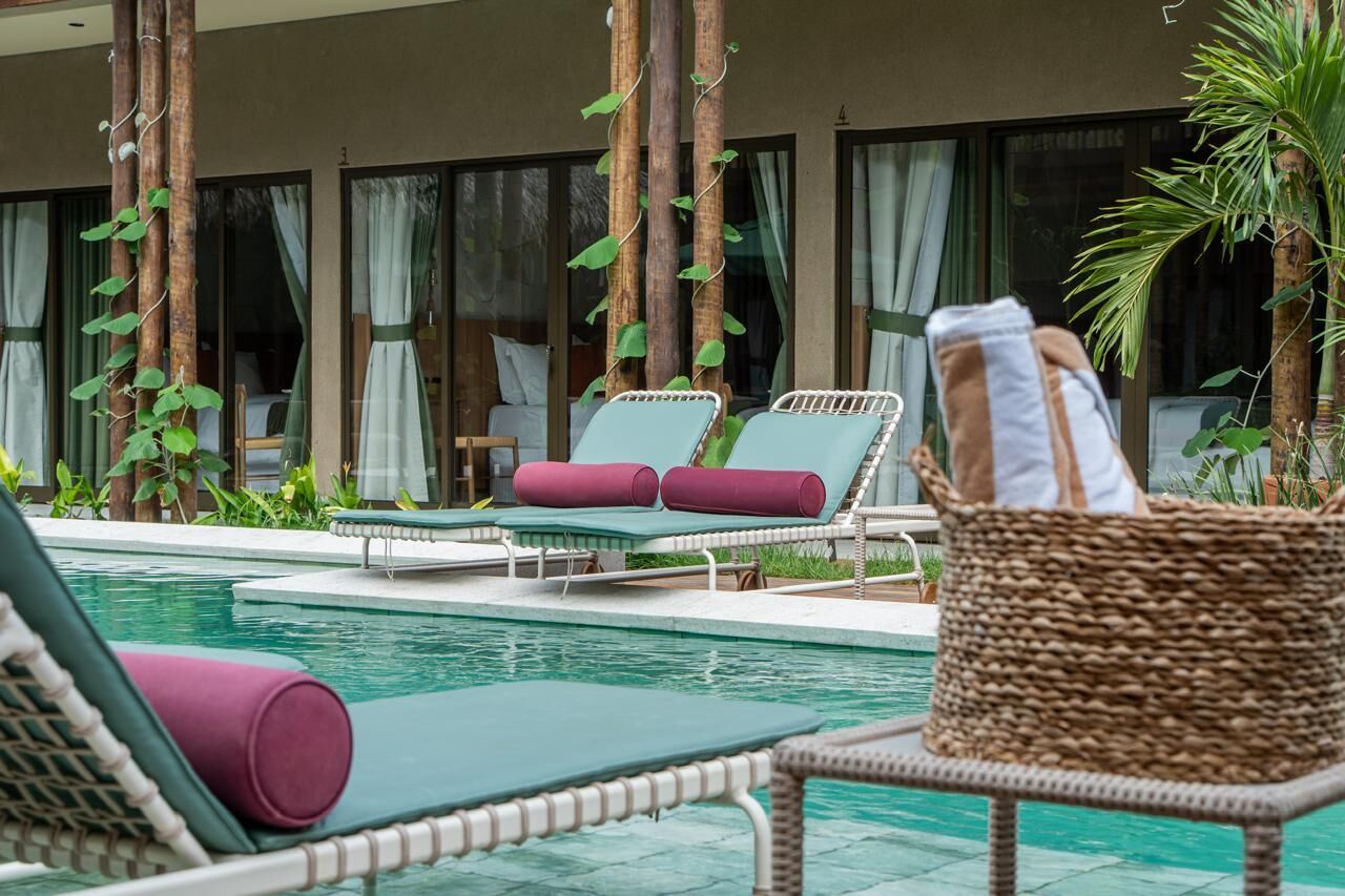 A poolside area with lounge chairs and a wicker basket.