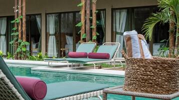A poolside area with lounge chairs and a wicker basket.