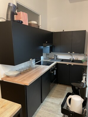 Een koelkast, een oven, een kookplaat, een koffiezetapparaat/waterkoker