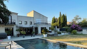 A modern house with a swimming pool, outdoor furniture, and a patio area. - Magnifique Villa D'architecte A 10 Minutes D'avignon (Tavel)