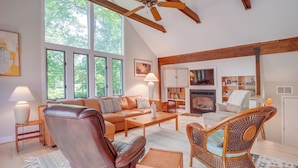 A spacious living room with a high ceiling, large windows, a fireplace, and a cozy seating area. - Mtn & Lake Views: Serene Wintergreen Resort Escape (Nellysford)