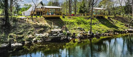 Une propriété au bord du lac, comprenant un bâtiment principal et une terrasse en bois.